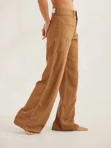 Pantalón negro de tiro medio alto, corte palazzo, con bolsillos delanteros y traseros.