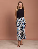 Pantalón capri estampado con flores en tonos celeste, blanco y negro. Tiene pretina elastizada en la parte trasera y bolsillos delanteros.