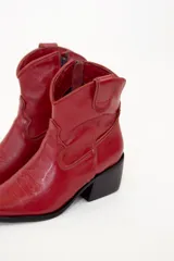 Bota texana corta de cuero color rojo, con punta fina, caña baja y taco cuadrado.