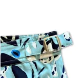 Short de baño celeste con estampado de motivos marinos en tonos azules y marrones. Tiene pretina fija con hebillas metálicas laterales, botón a presión y cierre frontal. Incluye tres bolsillos, interior de mesh hipoalergénico y accesorios waterproof.