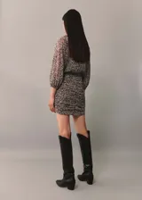 Vestido corto con estampado animal print, cuello redondo, mangas largas y detalles drapeados.