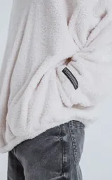 Hoodie blanco de piel de corderito sintético, corte oversize, con capucha ajustable con cordón y bolsillo canguro.