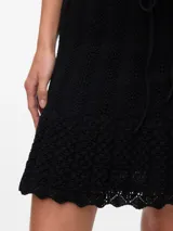 Pollera tejida de algodón y poliéster, color negro, de tiro medio, con textura de punto plano y ruedo con volado.