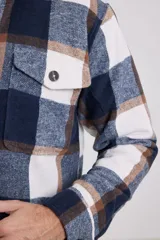 Sobrecamisa de franela a cuadros azules y blancos, con cuello clásico, cierre frontal con botones, bolsillo de parche en el pecho y corte recto.