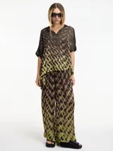 Blusa marrón con estampado animal print en tonos verde y negro, cuello camisero y botones en la parte delantera.