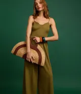 Mono largo color verde oliva, de breteles finos y escote corazón. Presenta recortes en el busto y la cintura, además de pliegues.