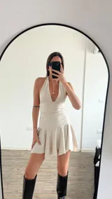 Vestido corto marrón con escote halter y falda con volados.