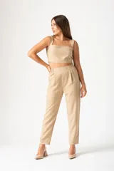 Pantalón color beige con finas líneas verticales blancas, tiro alto y corte palazzo.