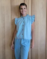 Musculosa blanca de lino con cuello mao y volados en los hombros. Cierre frontal con botones.