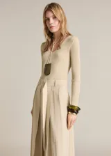 Vestido midi color beige de tejido de punto acanalado, con escote en V y mangas largas.