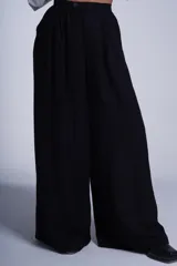 Pantalón de vestir color beige, de corte palazzo, con cintura alta, pinzas delanteras y elástico en la parte trasera de la cintura.