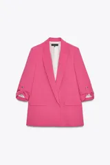 Blazer fucsia de corte recto, con cuello solapa y mangas 3/4 con trabilla y botón dorado. Tiene bolsillos delanteros con solapa.