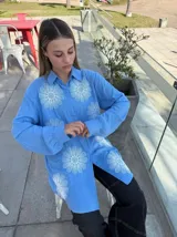 Camisa celeste con estampado de flores blancas, de corte holgado y manga larga.