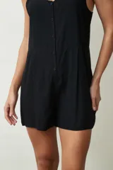 Mono corto color crudo, con breteles finos, escote en V y cierre frontal con botones.