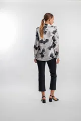Camisa de manga larga color blanco con estampado de grullas negras.