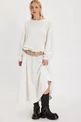 Camiseta de manga larga blanca, confeccionada en tejido acanalado con silueta holgada y hombros caídos. Presenta costuras marcadas con terminaciones sin rematar.