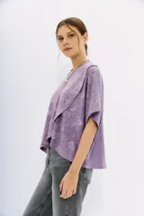 Remera lila con estampado de cachemir, de mangas cortas y cuello redondo. Tiene calce amplio y corte cruzado al frente.
