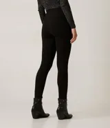 Pantalón negro de corte skinny confeccionado en tejido de punto roma. Diseño de sastrería con costuras frontales y cierre lateral con cremallera.