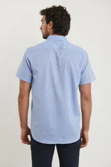 Camisa celeste de manga corta con cuello abotonado y bolsillo en el pecho.