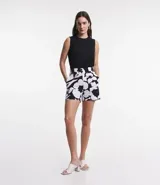Blusa sin mangas color celeste, de crepé, con cuello redondo, pliegues en uno de los hombros y cierre trasero por cremallera con detalle de aro en el tirador.