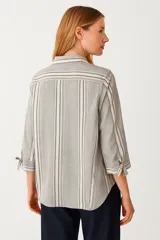Camisa a rayas verticales grises y blancas, de corte holgado, con cuello clásico, cierre frontal con botones y mangas 3/4 con lazo.