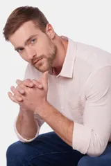 Camisa de lino color beige, de manga larga, con cuello clásico y bolsillo en el pecho.