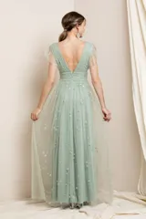 Vestido largo de fiesta color azul acero, con escote en V, mangas cortas de tul fruncido y falda de tul con abertura lateral y estampado de estrellas plateadas.