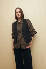 Camisa marrón con estampado animal print, cuello clásico, abotonadura frontal y mangas largas con puños elastizados.