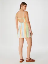 Vestido corto con tirantes finos y estampado a rayas verticales en tonos pastel: verde, naranja, celeste, rosa y blanco.