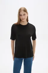 Remera negra de viscosa con textura acanalada, corte holgado y cuello redondo.