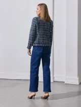 Chaqueta tipo blazer en tejido tweed azul con detalles en blanco y lurex. Tiene escote mao, abertura central, bolsillos delanteros y puños con aplique de botones perlados. Terminación desflecada y forro interno.