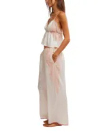 Conjunto de pijama de satén color crema, compuesto por un top sin mangas con escote en V y detalles de encaje rosado, y un pantalón palazzo con cintura elastizada y detalles de encaje rosado en los laterales.