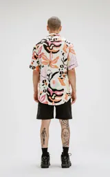 Camisa de manga corta con estampado abstracto multicolor, calce oversize y canesú en la espalda.