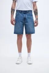 Bermuda de jean azul de corte holgado en la cadera y levemente ajustada en las piernas, con tiro medio.