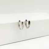 Par de aros pequeños de plata 925 con forma de gota y detalle de circonias incrustadas.