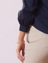 Blusa azul marino de gasa con escote en V y mangas largas con puño.