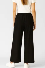 Pantalón negro ancho con rayas blancas laterales y cintura elastizada con cordón ajustable.