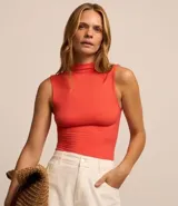 Blusa sin mangas en viscosa color blanco, con cuello alto y textura acanalada.