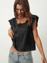 Blusa negra de satén con escote en V y detalle de encaje en el escote.