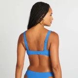 Top de bikini azul con textura acanalada, escote en V y detalle de abertura en el centro del busto.