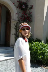 Gorro tipo bucket tejido al crochet con diseño a rayas horizontales en tonos marrón, rosa y beige.