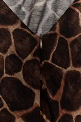 Vestido largo de tela estampada con patrón de jirafa, corte recto y cuello halter anudado en la parte superior.