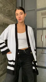 Saco blanco con ribetes negros, de tejido de punto y corte oversize.