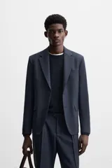 Blazer azul marino de corte recto confeccionado en tejido con lana. Tiene cuello con solapas de muesca, manga larga con puños abotonados, bolsillo de vivo en el pecho, bolsillos de solapa en la cadera, bolsillo interior y cierre frontal con botones.