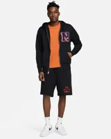 Campera negra con capucha y cierre frontal, con logo de Nike bordado en blanco en el puño izquierdo y una letra N grande en el pecho con borde naranja y relleno azul.