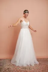 Vestido largo de fiesta color blanco, con breteles finos, corpiño con ballenas y apliques de flores bordadas. Falda de microtul con brillo.
