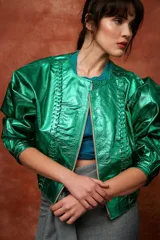 Campera marrón de cuero con cierre frontal, corte oversize, mangas abullonadas y puños ajustados.