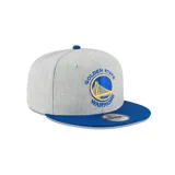 Gorra gris con visera azul, logo de los Golden State Warriors bordado en el frente y logo de New Era bordado en el lateral.