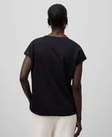 Camiseta negra de algodón orgánico, corte holgado, cuello en V y mangas cortas con hombro caído.