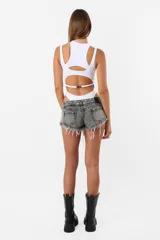 Body blanco de microfibra con aberturas y piezas superpuestas en el delantero y espalda. Diseño musculosa sin mangas, cuello redondo y detalle de chapita TE en la espalda. Cierre con broches snap en la entrepierna y elástico interno en el tiro y bordes para mejor ajuste.